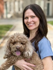 Photo of Dr Germanis holding a tan, doodle-type dog